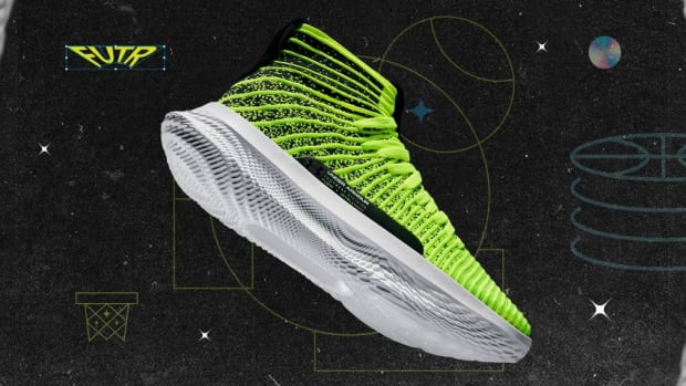 Side view of a yellow and white Under Armour basketball shoe.